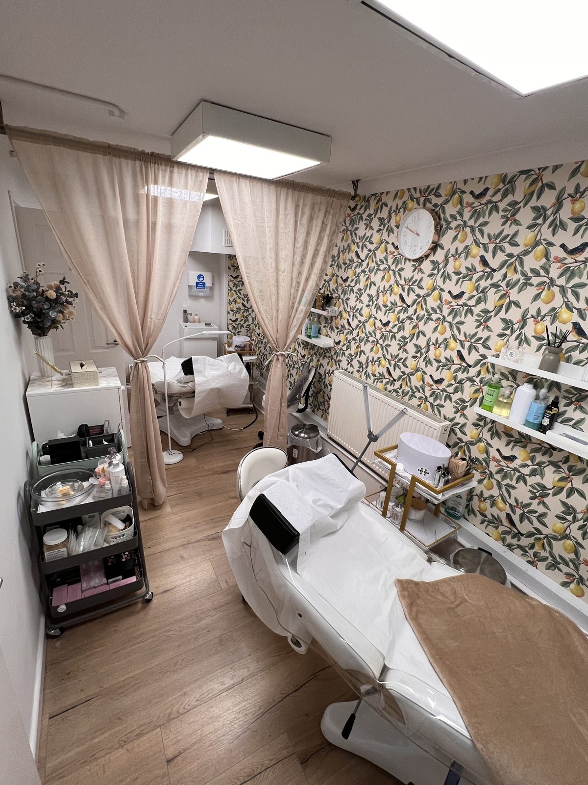 The treatment room with its lemon wallpaper and curtained beds